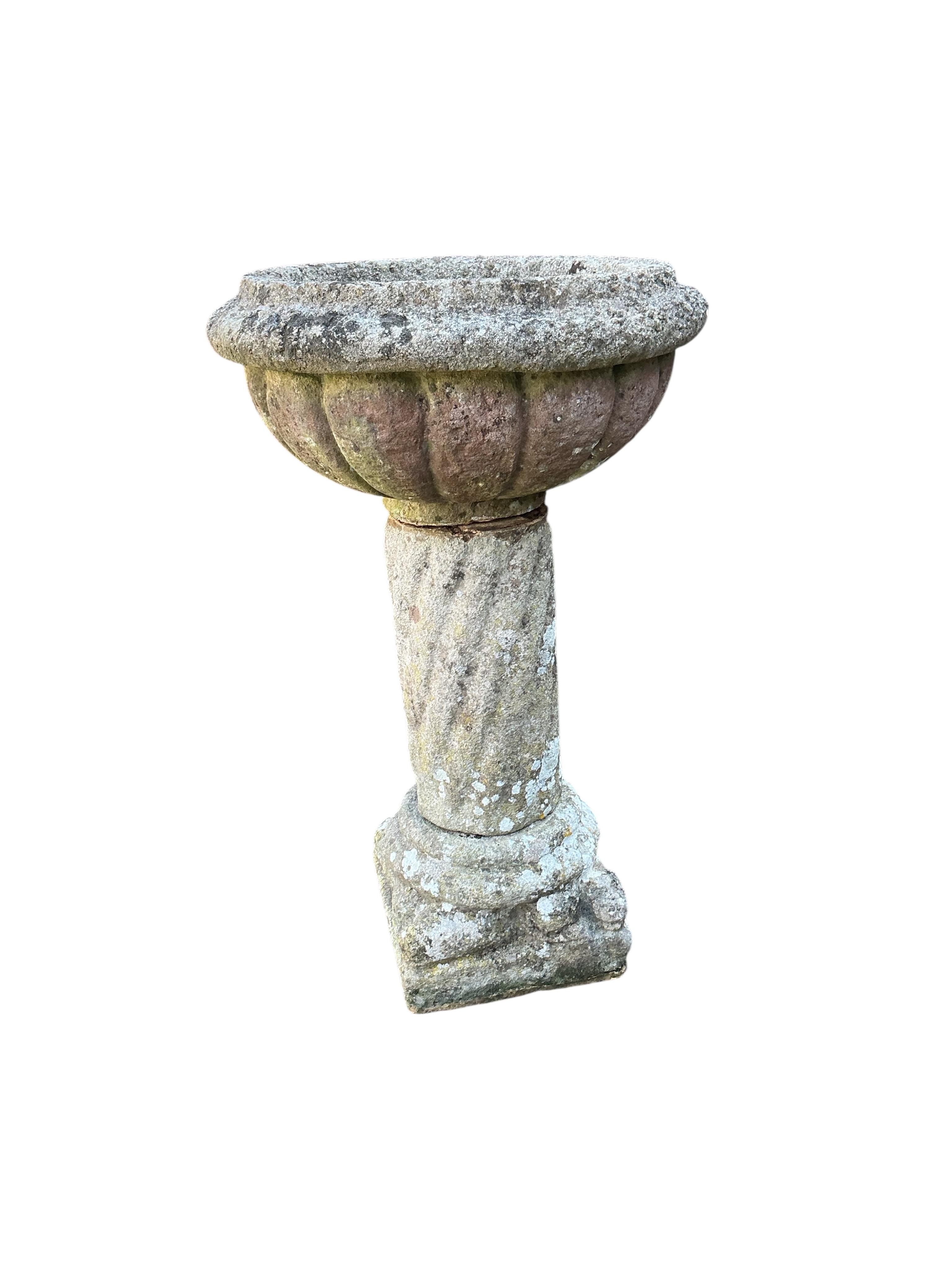 A reconstituted stone garden planter, diameter 54cm, height 90cm